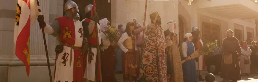 Desfile con trajes medievales y estandartes al sol