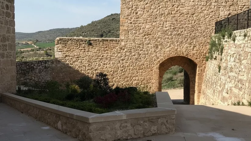 Patio interior con arco y muros fortificados.