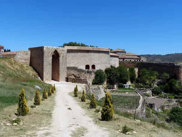 Muralla de piedra con gran puerta apuntada.