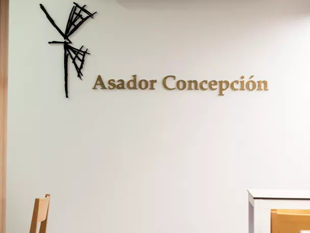 Logotipo dorado en pared blanca minimalista