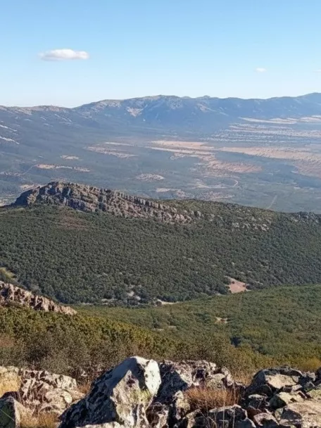 Vista panorámica de sierras y valles desde una ladera rocosa