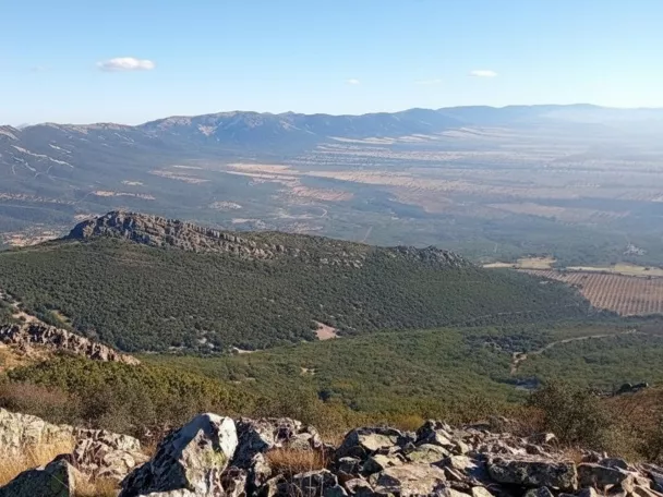 Vista panorámica de sierras y valles desde una ladera rocosa