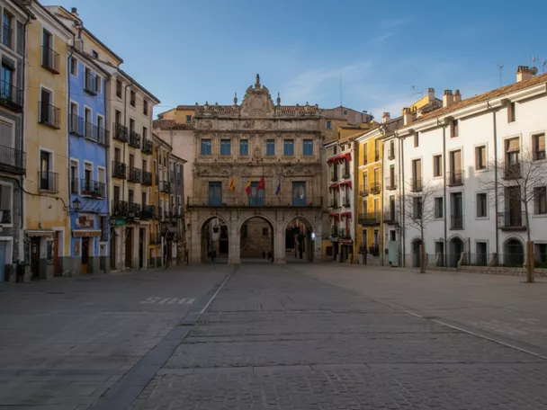 Plaza histórica con edificio porticado y fachadas coloridas