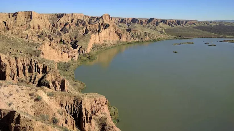Paredes naturales de arcilla junto a una amplia lámina de agua
