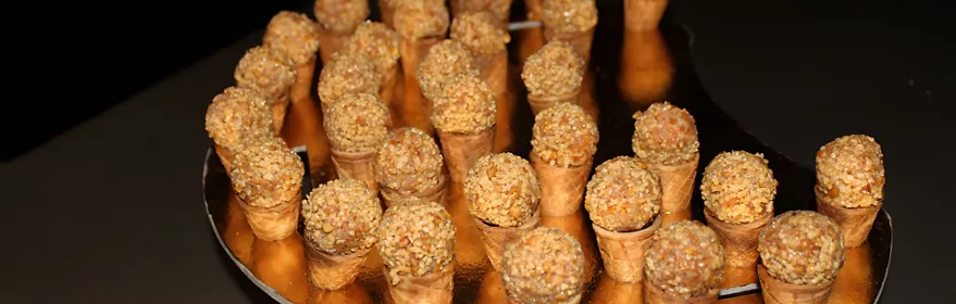 Bandeja con bocados en cucuruchos sobre fondo oscuro