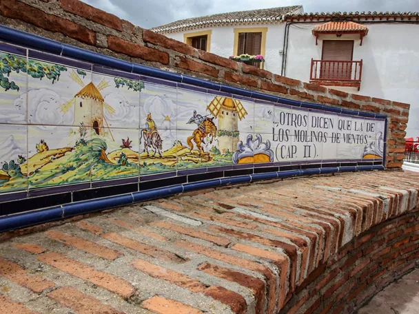 Banco de ladrillo con mural cerámico de molinos y caballeros