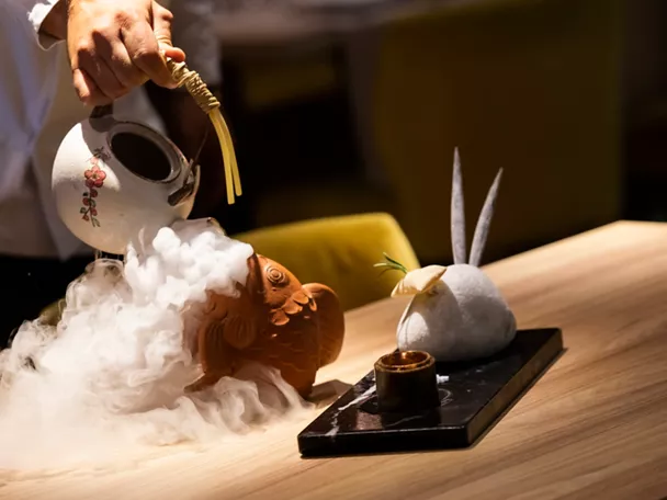 Servicio de plato con humo en mesa de madera