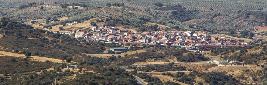 Vista aérea de un pueblo rodeado de colinas y olivares