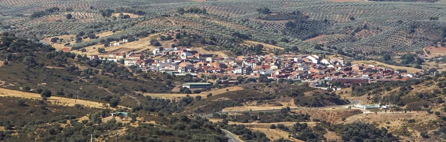 Vista aérea de un pueblo rodeado de colinas y olivares