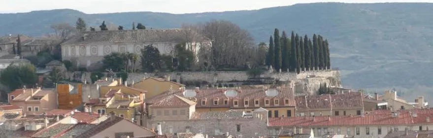 Vista panorámica de tejados rojizos y edificios históricos en un valle.