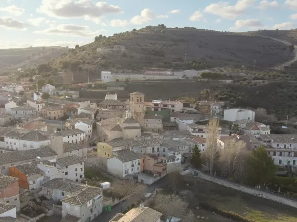 Vista panorámica de núcleo rural con tejados y colinas al fondo