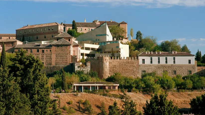 Conjunto histórico amurallado sobre una colina con edificios de piedra.