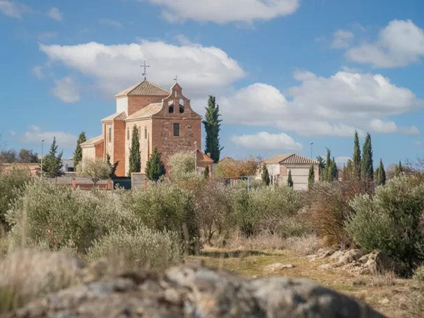 Vista general de un pueblo con tejados rojizos y paisaje montañoso al fondo
