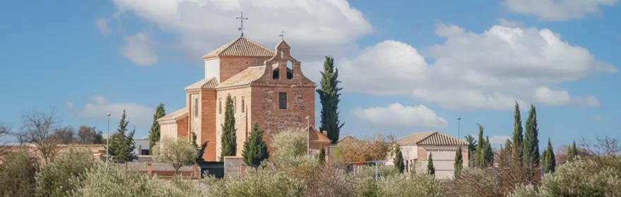 Vista general de un pueblo con tejados rojizos y paisaje montañoso al fondo