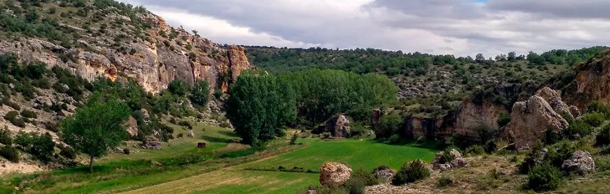Valle fluvial entre cañones rocosos.