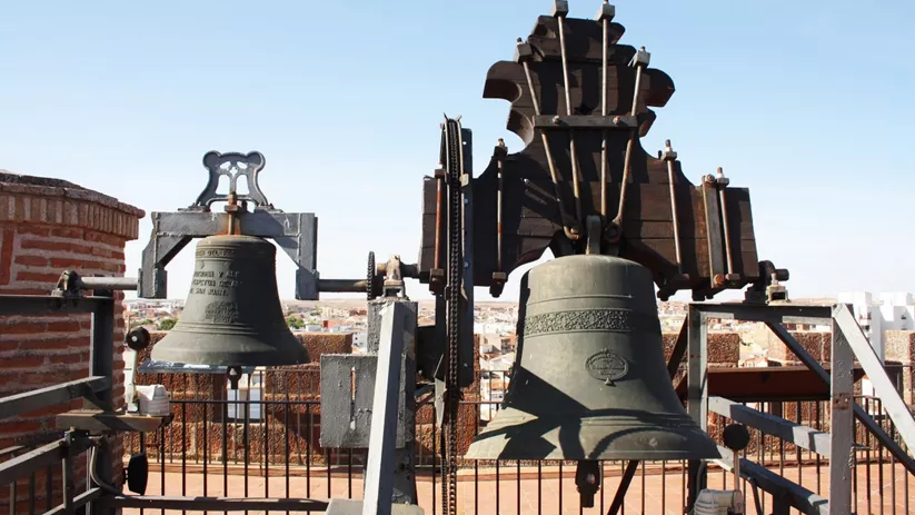 Campanas en estructura metálica sobre azotea con vista urbana.