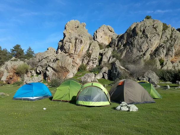 Zona de acampada junto a formaciones rocosas.