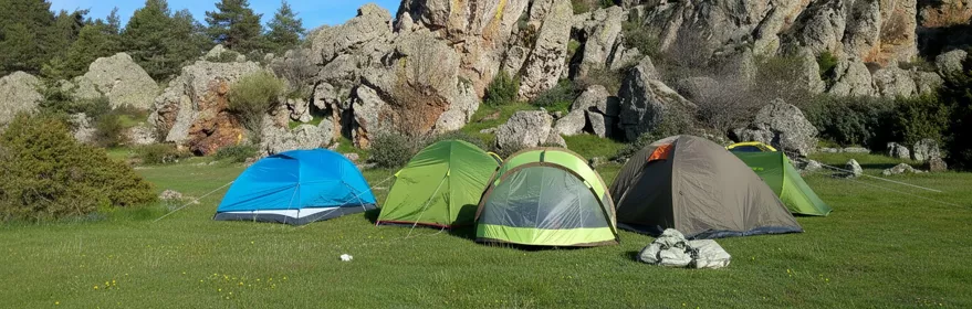 Zona de acampada junto a formaciones rocosas.