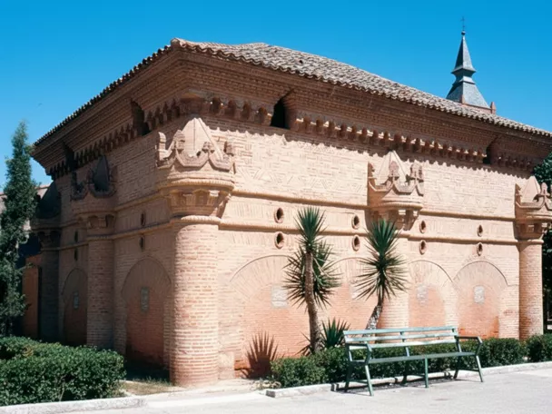 Fachada de ladrillo con columnas cilíndricas y arcos decorativos.