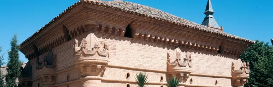 Fachada de ladrillo con columnas cilíndricas y arcos decorativos.
