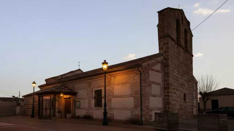 Iglesia de piedra iluminada al atardecer en la plaza