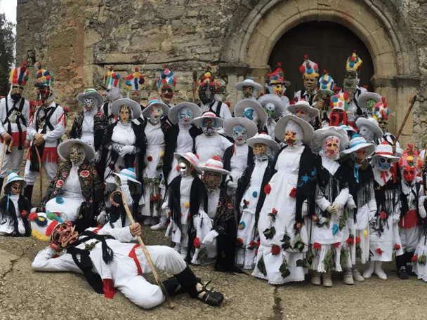 Fiesta tradicional con máscaras y trajes populares.