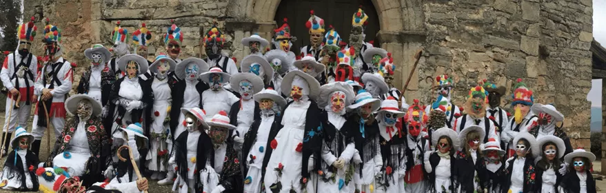 Fiesta tradicional con máscaras y trajes populares.
