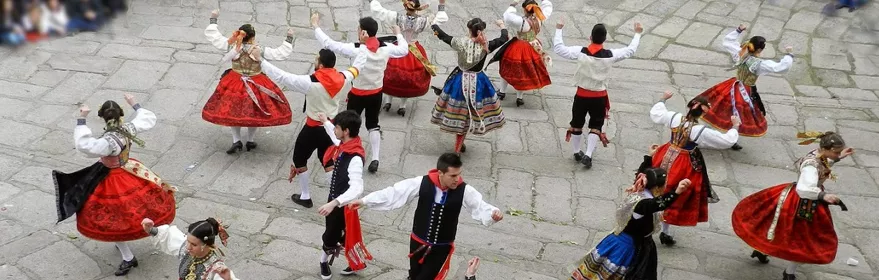 Grupo de baile con trajes tradicionales en corro al aire libre.