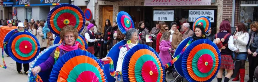 Personas con grandes rosetones de colores desfilando por la calle
