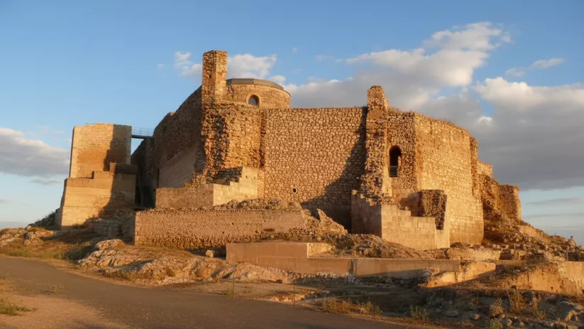 Castillo de Calatrava la Vieja en Carrión de Calatrava, fortaleza medieval iluminada por la luz del atardecer.