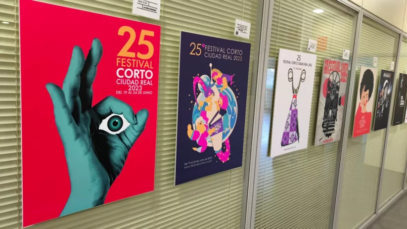 Carteles de festival cultural expuestos en un pasillo interior.