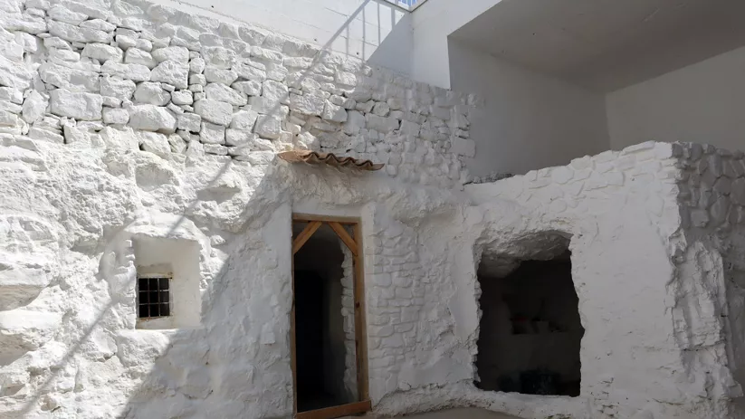 Fachada encalada de vivienda excavada con accesos en la roca