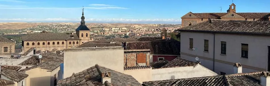 Vista de tejados y campanarios bajo cielo azul
