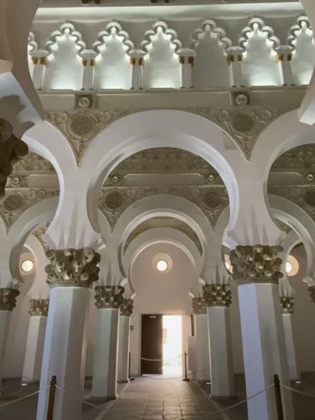 Interior con columnas blancas y capiteles decorados en estilo histórico.