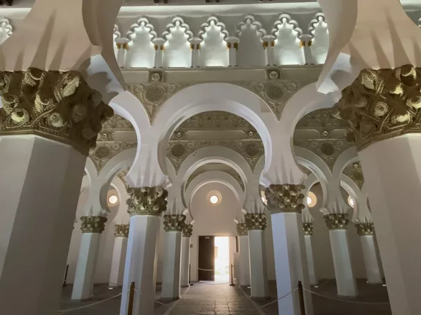 Interior con columnas blancas y capiteles decorados en estilo histórico.
