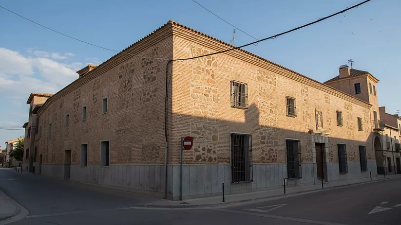 Gran edificio de ladrillo en esquina de calle urbana