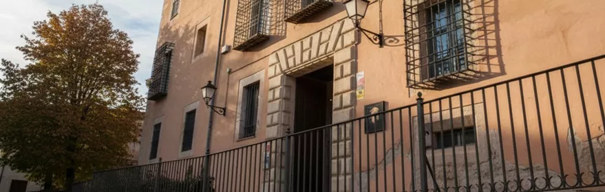 Fachada histórica con balcones y rejas metálicas.