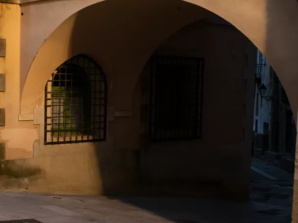 Fachada con soportales y ventanas enrejadas al atardecer
