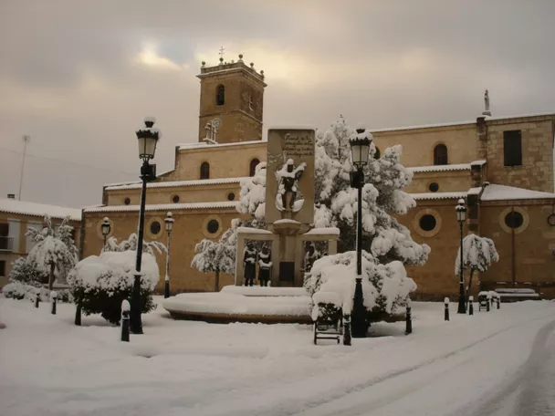 Conjunto monumental cubierto de nieve en una plaza tranquila.