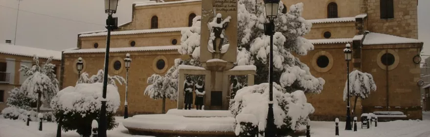 Conjunto monumental cubierto de nieve en una plaza tranquila.