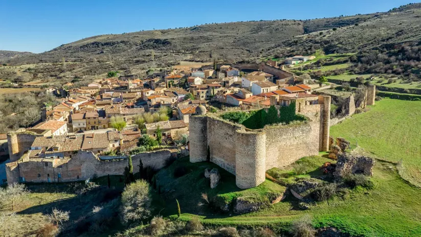 Vista aérea de recinto amurallado junto a caserío rural