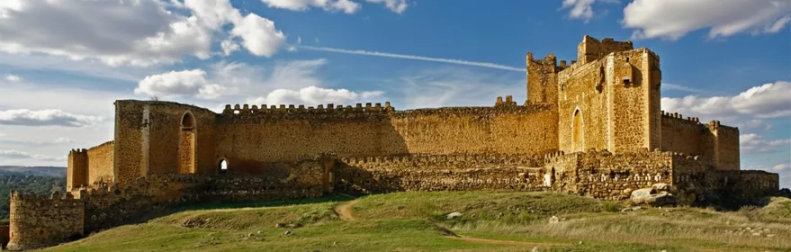 Vista panorámica de fortaleza amurallada sobre colina verde