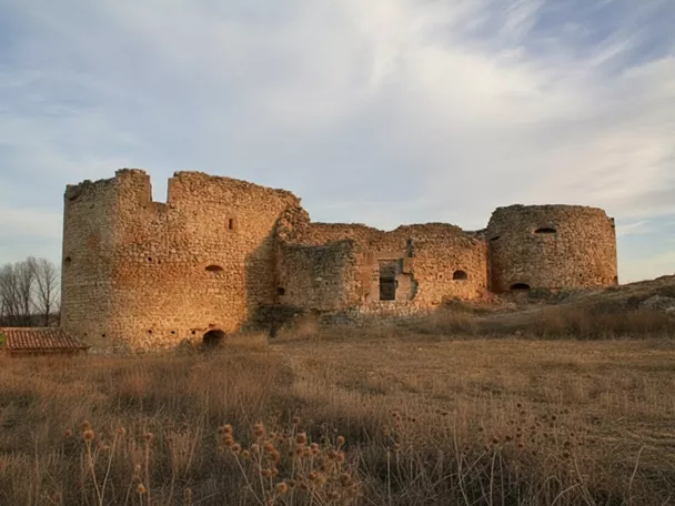 Castillo en ruinas sobre colina al atardecer