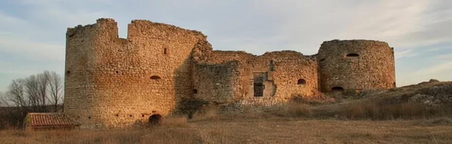 Castillo en ruinas sobre colina al atardecer