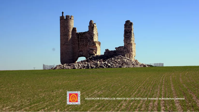 Ruinas de castillo sobre campo verde bajo cielo azul