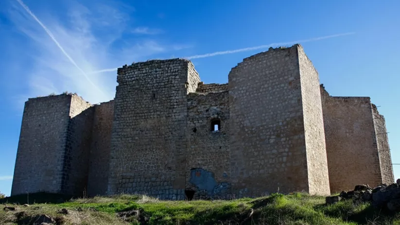 Murallas y torres de piedra bajo cielo despejado.