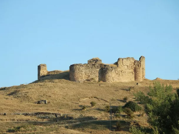 Ruinas de fortaleza en lo alto de una colina seca.