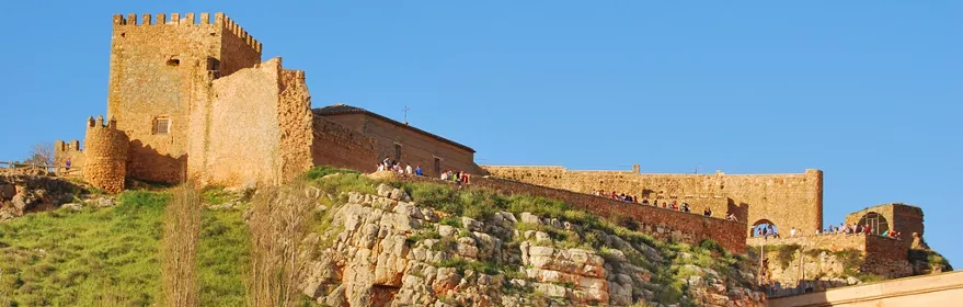 Castillo medieval sobre roca junto a embalse