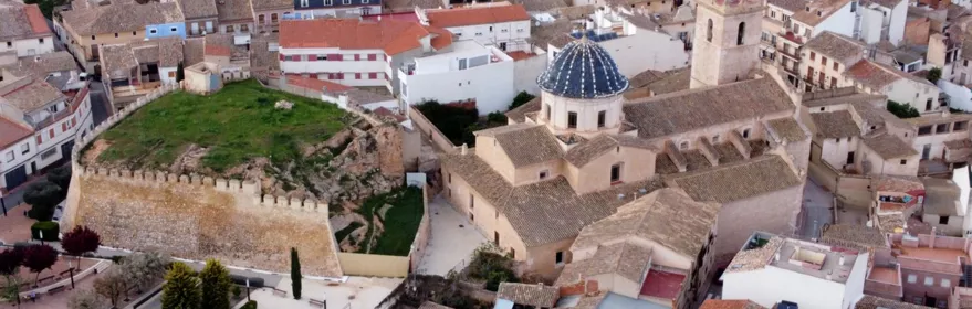 Vista aérea de fortaleza y conjunto urbano con tejados tradicionales.