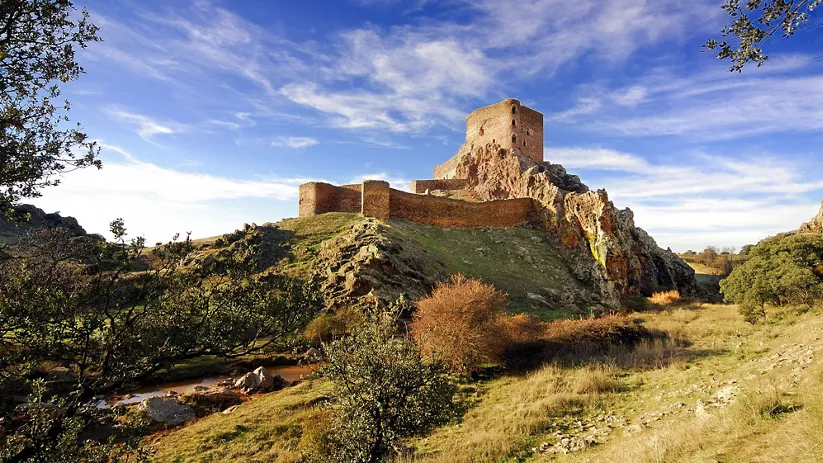 Fortaleza de piedra sobre una colina rocosa.